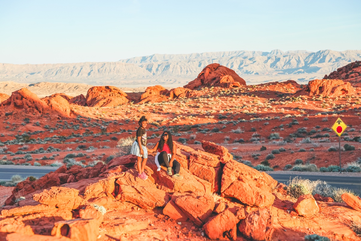 Shaneice and her daughter standing on red rocks in the desert at golden hour
